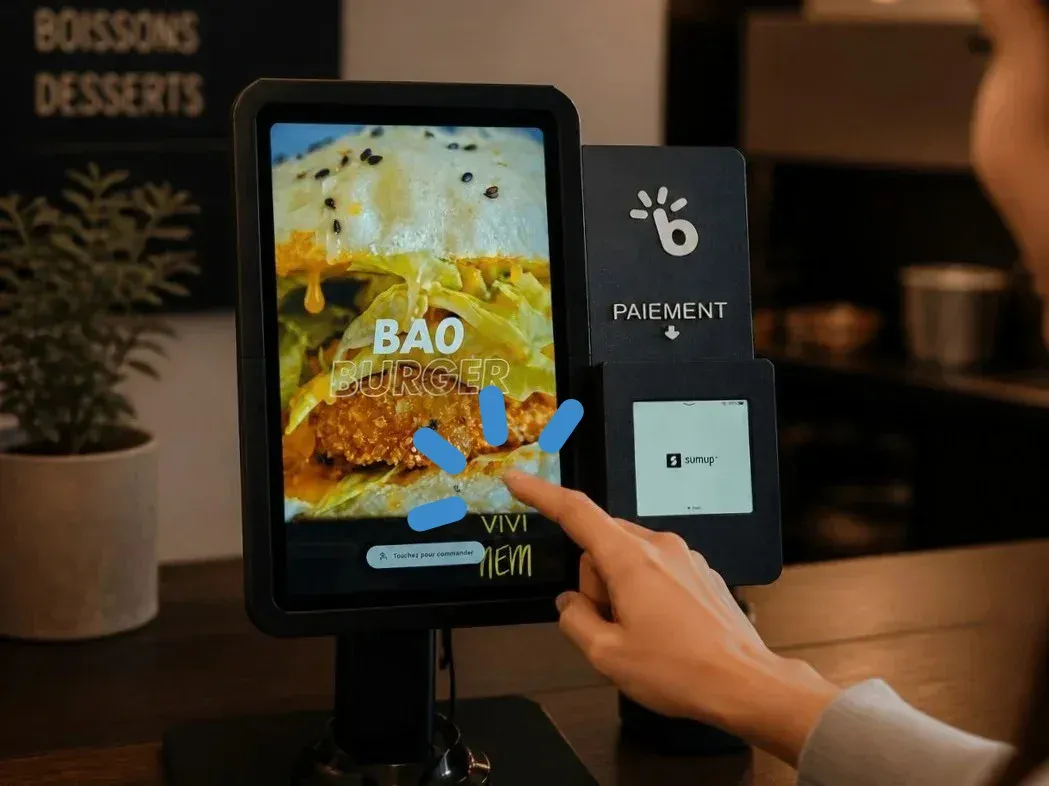 Client commandant un burger sur une borne BorneHub, terminal SumUp intégré